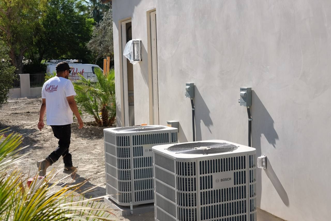 Joe Alvarado walking beside Bosch IDS condensers set outside a South La Quinta custom home