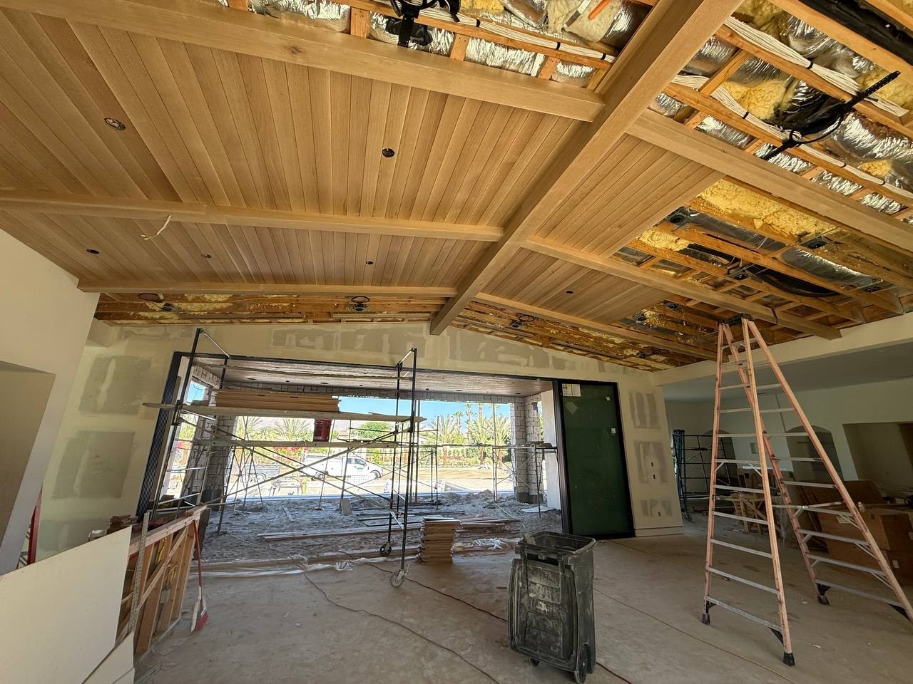 Tongue-and-groove ceiling installation in the great room with HVAC and wiring visible above