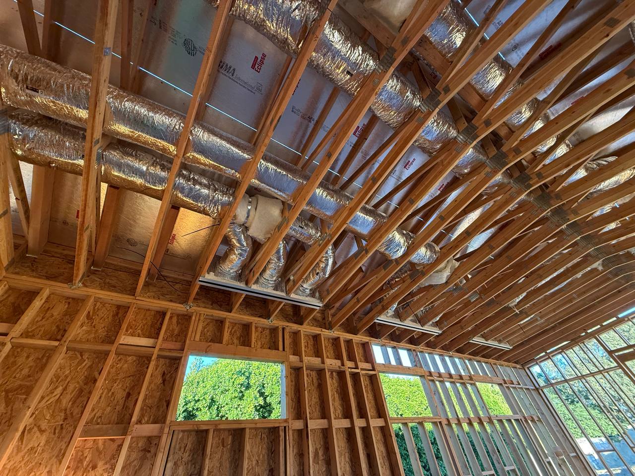 Rough-in ductwork inside the barn structure — flexible insulated duct runs