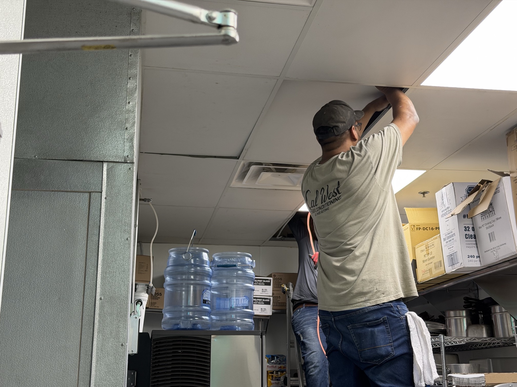 Cal West technician completing ceiling and refrigerant-line work inside the restaurant